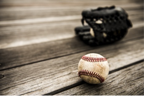 Baseball glove and baseball on table.